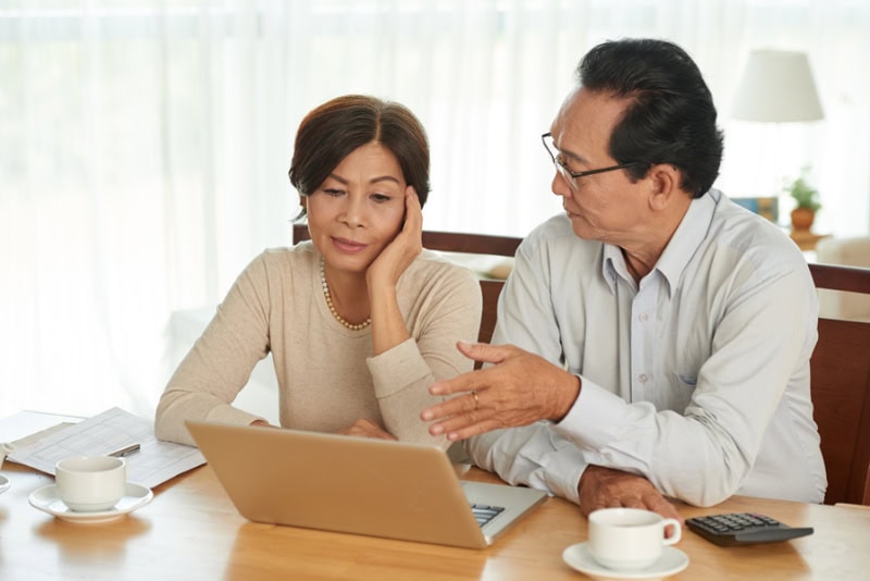 unhappy senior couple discussing their home budget.