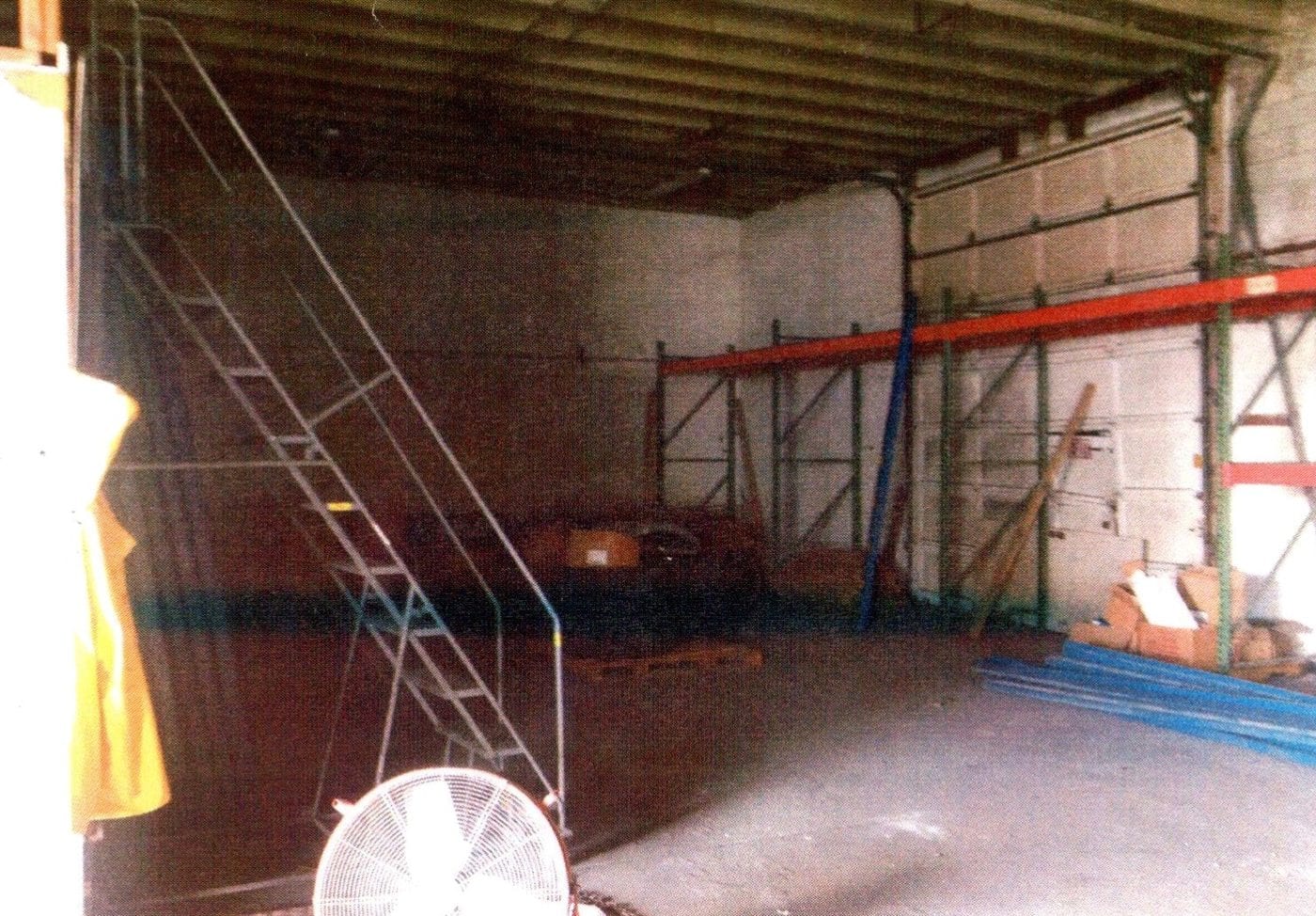 Warehouse interior before renovation with racking and stairs