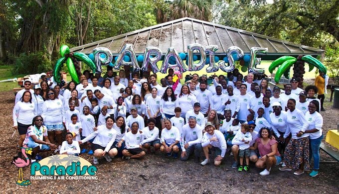 Paradise employees and their families gathered under PARADISE balloons in matching white shirts
